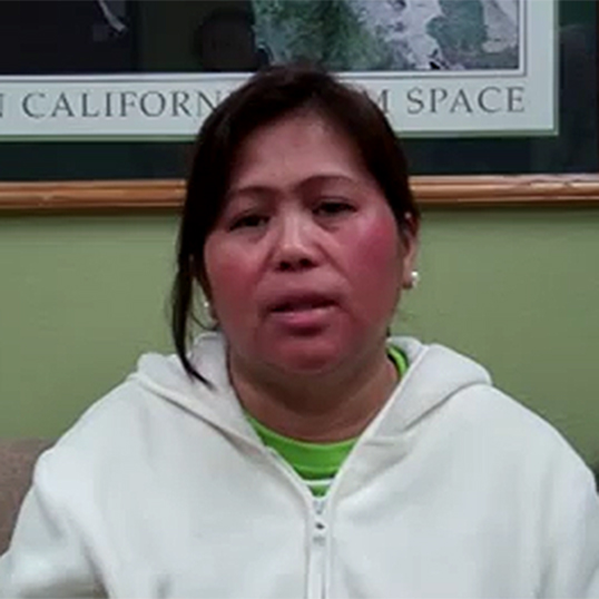A woman wearing a hoodie testifies to her experience with prayer
