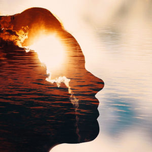 Multiple exposure image; glaring sun from behind a cloud, a woman's silhouette looking toward the sky, a backdrop of rippling water