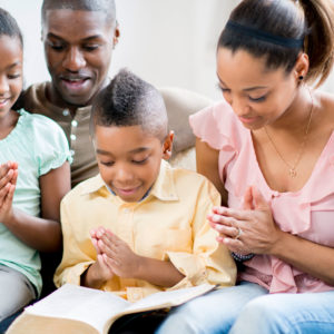 A young black family prays together