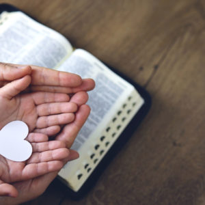 Heart in hands on a bible