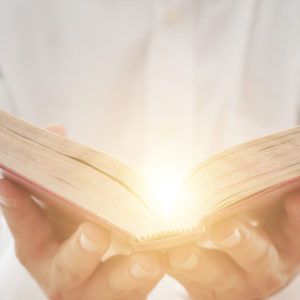 Man reads a glowing bible