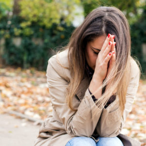 A grieving woman kneels in prayer