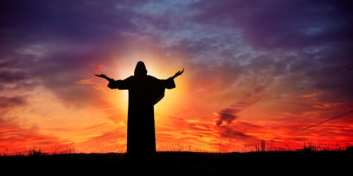 Jesus is depicted, arms raised and glowing, silhouetted against a bright sunset