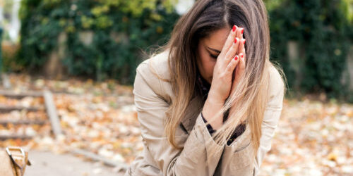 A grieving woman kneels in prayer